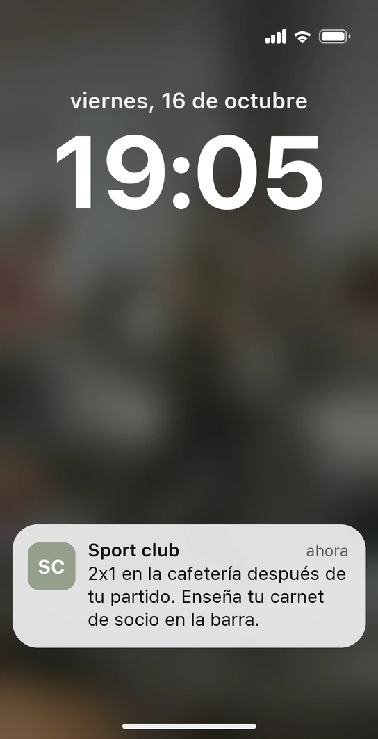 Pantalla de bloqueo de un iPhone con la notificación del carnet de socio de un centro deportivo: 2x1 en la cafetería después del partido