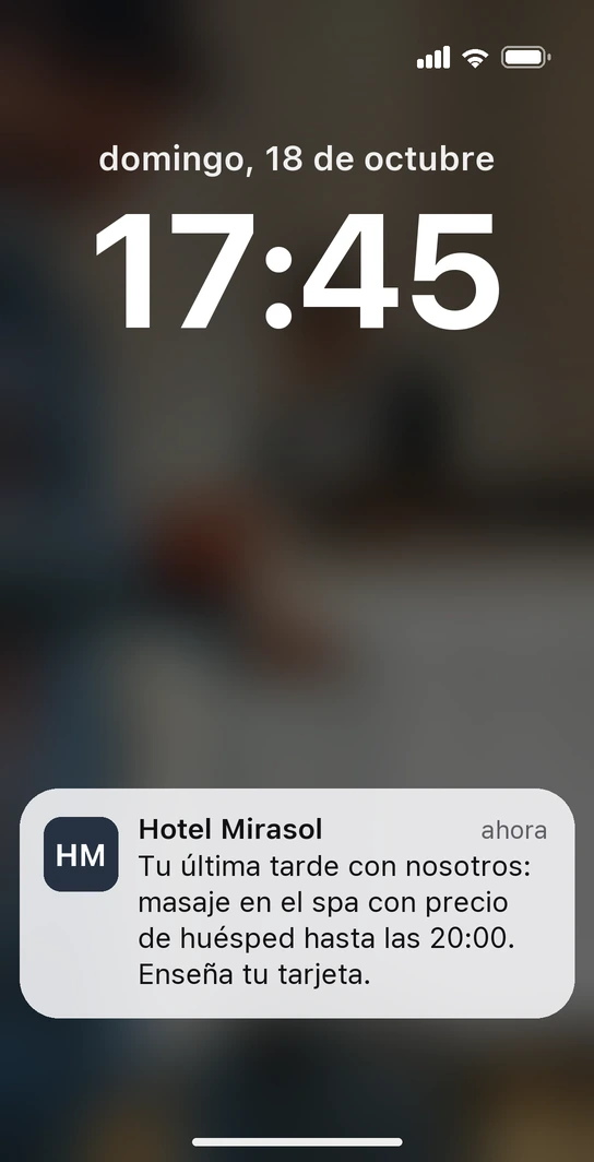 Pantalla de bloqueo de un iPhone con la notificación de la tarjeta de huésped del Hotel Mirasol: masaje en el spa con precio de huésped la última tarde
